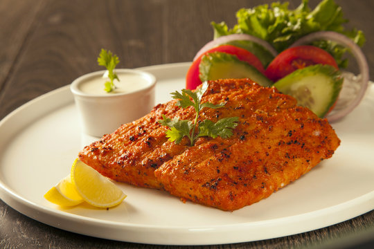 Grilled Fish Tikka Served On A Plate With Salad And Tarter Sauce