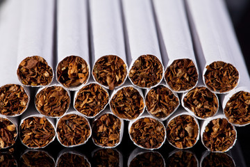 some thin cigarettes on black background close up