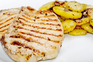 Pork steak fried potatoes on white plate