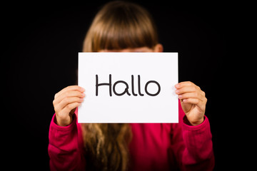 Child holding sign with German word Hallo - Hello in English