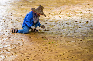 Employee renews the floor in front of one of the temples