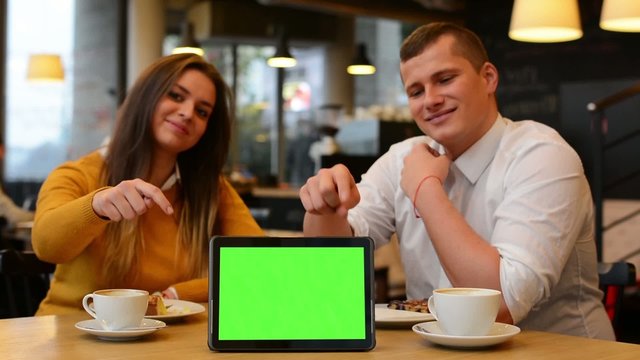 tablet green screen - happy couple smiles and point at tablet