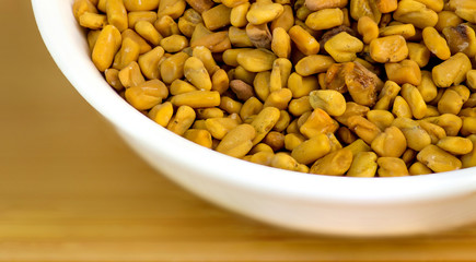 Macro closeup of fenugreek in white bowl