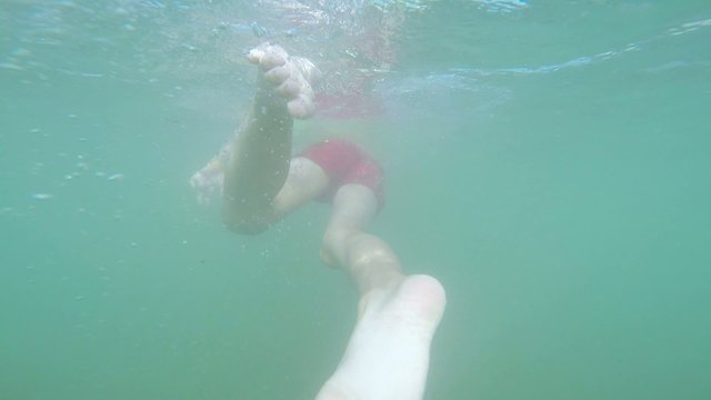 little boy swimming under water in the sea