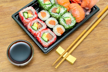 Japanese cuisine: rolls and sushi on a bamboo board close-up.