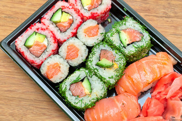 sushi, rolls and pickled ginger on a bamboo board close-up