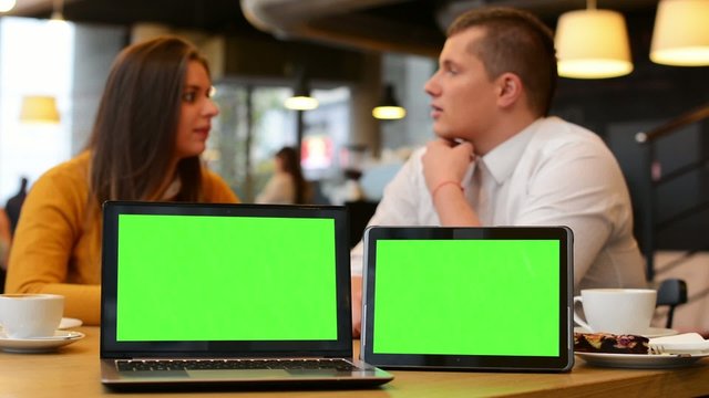 tablet and computer green screen - happy couple talk in cafe