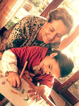 Abuela viendo a su nieta dibujar