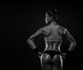 Fototapeta na wymiar Athletic young woman showing muscles of the back