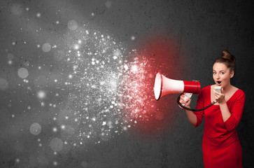 Woman shouting into megaphone and glowing energy particles explo