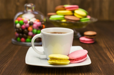 Obraz na płótnie Canvas Coffee with colorful macaroons and candies