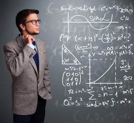 Handsome school boy thinking about complex mathematical signs