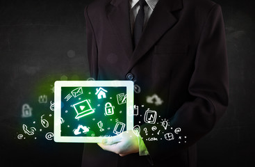 Person holding tablet with green media icons and symbols