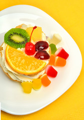 Christmas fruit cake with cream on white plate isolated on white