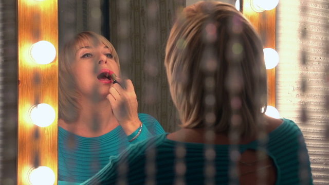 beautiful woman paints her lips, slow motion, dolly 1