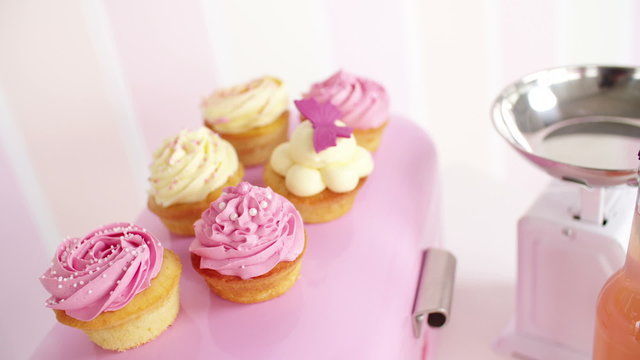 Beautifully decorated pink and white cupcakes in kitchen