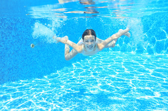 Underwater child swims in pool, girl swimming, kids sport