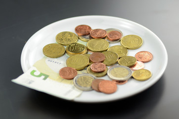 Münzen auf Teller
