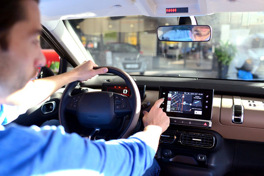 Mann bedient Navigationsger&auml;t im Auto