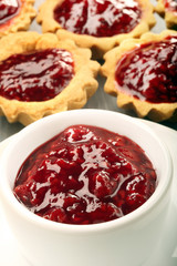 Blueberry jam in white jar and muffins
