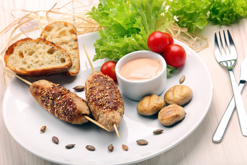 Minced meatballs baked as skewers with sesame seeds