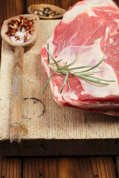 raw shoulder lamb on wooden board and table