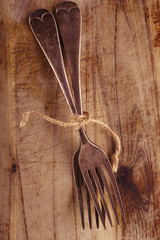 two fork tied by string on old wood, background