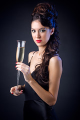 Fototapeta na wymiar Portrait of beautiful girl in evening dress with wine glass. New