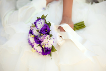 White and purple wedding bouquet with eustomas in hands