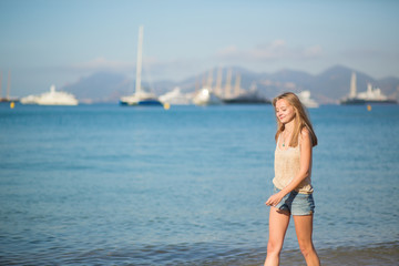 Fototapeta na wymiar Young girl walking on the beach in Cannes, France