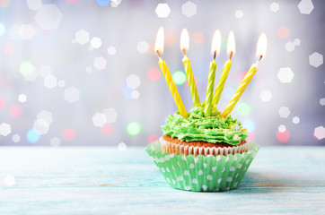 Delicious birthday cupcake on wooden table