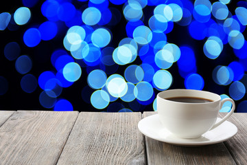Cup of hot drink on bright background