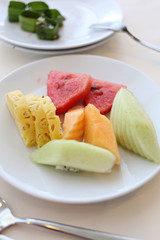 Mixed fruits in white dish.