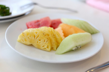 Mixed fruits in white dish.