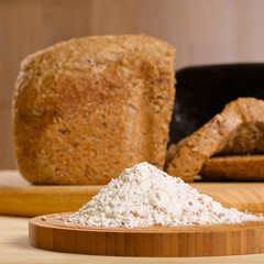 Gluten free flour with cutted fresh bred on wooden table