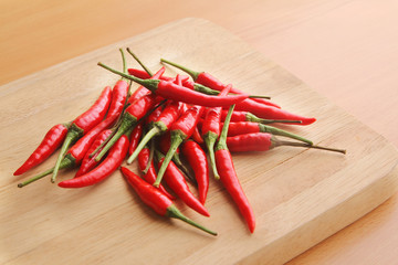 Pile of red chillies on wooden chopping board