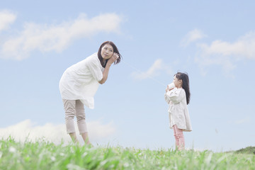 糸電話で遊ぶ母親と子供