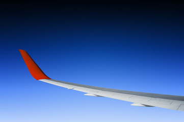 view of airplane wing on blue sky