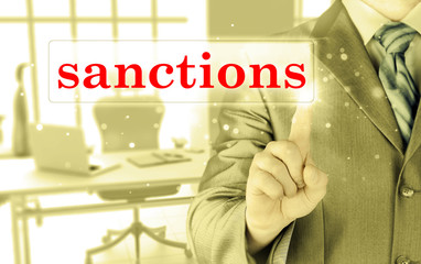 businessman pressing sanctions button on virtual screens