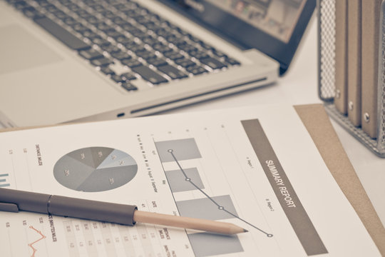 Analyzing investment charts with laptop. Accounting