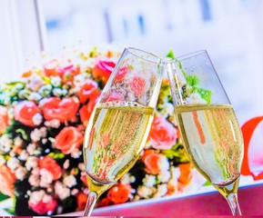 champagne flutes on wedding flowers background