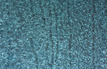 Blue frozen glass. Abstract winter background.