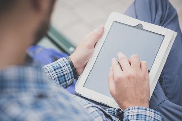 close up hands man using tablet on the bench