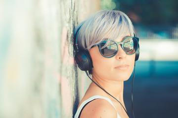 young beautiful short blue hair hipster woman with headphones mu