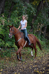 Joyful girl riding horse in forest
