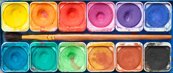 Set of watercolor paints and paintbrush.