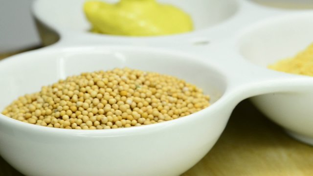 Senfk&ouml;rner, Senfmehl und Senf auf einem Drehteller