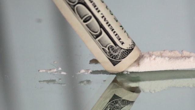 Cocaine snorting on a mirror through  100 dollar