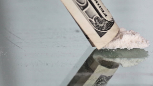 Cocaine snorting on a mirror through  100 dollar
