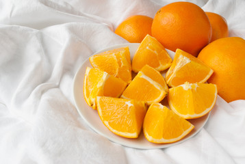 Naklejka na ściany i meble Cutted oranges on a cloth with white space